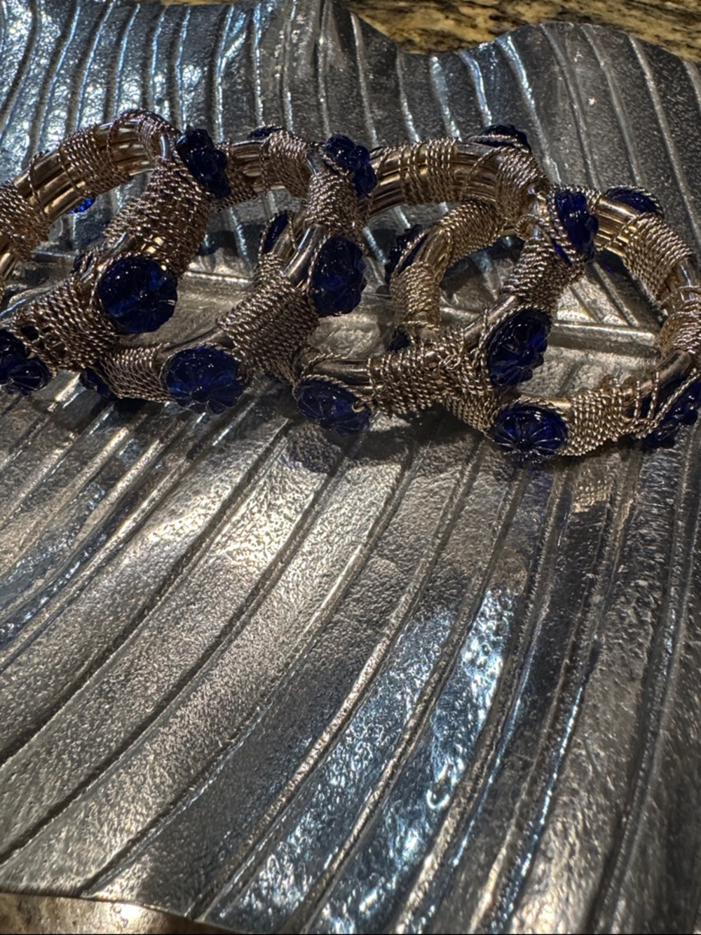 Set of 4 silvertone metal and blue glass napkin rings